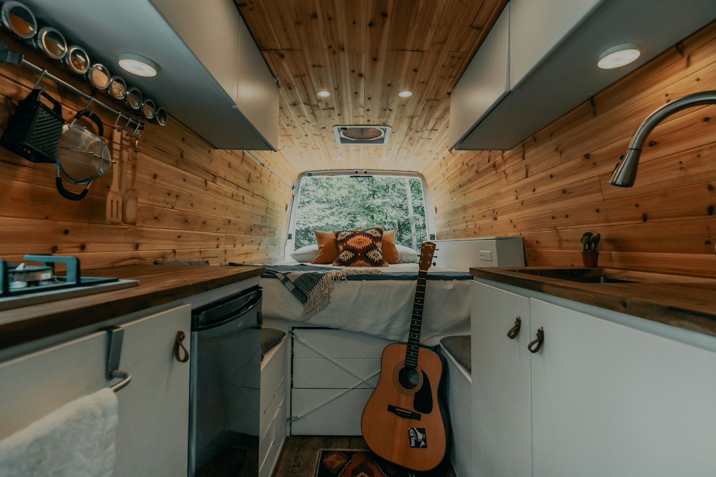 Gemütlicher Camper-Innenraum mit Holzwänden und einem Bett.